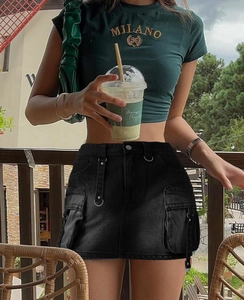 Détail de la mini-jupe cargo noire en denim avec poches plaquées et anneaux métalliques