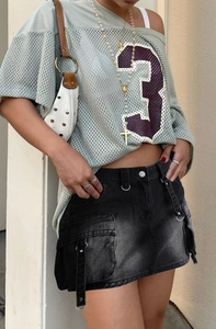 Détail de la mini-jupe en jean vintage avec de grandes poches cargo et boucle en D