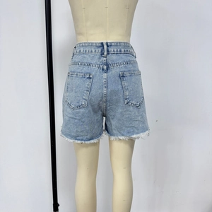 Detail view of denim shorts with fringe hem and acid wash effect on back pockets