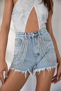 Detail of high waist denim shorts featuring shimmering silver rhinestone fringe and frayed hem