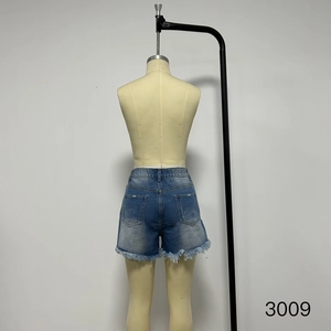 Detailed back view of vintage wash denim shorts featuring distressed pockets and fringe hems
