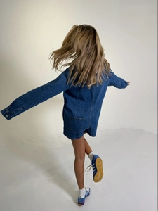 Vue détaillée du dos d'une combinaison en jean bleu foncé vintage avec coutures contrastées