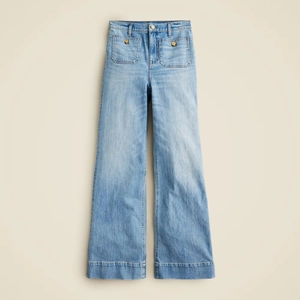 Detail of high waist light blue wide leg jeans with utility pockets and gold buttons