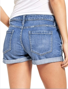 Detail view of denim shorts featuring rolled cuffs and symmetrical back pockets