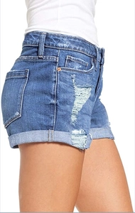 Side view of blue washed denim shorts featuring ripped details and cuffed hems for women