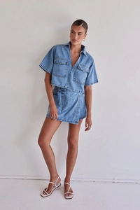 Detalle del conjunto de dos piezas de mezclilla con falda asimétrica y camisa de trabajo