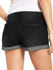 Detail view of the back pockets and rolled cuffs on black denim shorts for women