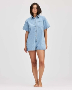 Vue détaillée du combishort en jean bleu clair avec col classique et boutons