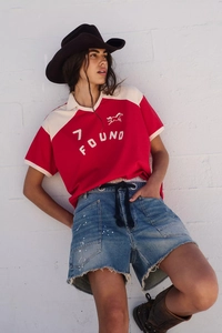 Outdoor street style featuring blue denim shorts with paint splatters and frayed edges