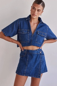 Detalle de conjunto denim azul oscuro con costuras en contraste y bolsillos cargo