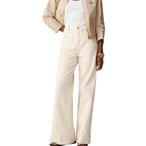 Detail of high-waisted wide-leg trousers with metal button fly and large side pockets