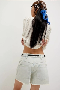 Rear view of light blue high waisted denim shorts with raw hem and pockets for women