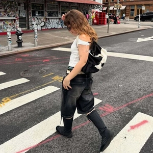Street style λήψη με γκρι ξεπλυμένη τζιν βερμούδα με ξεφτισμένες άκρες και μπότες