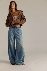 Detailed shot of high-waisted wide-leg denim jeans with a brown studded leather belt and jacket