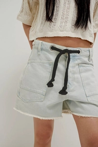 Detail of high-waisted denim shorts with thick black drawstring and frayed raw hem edge