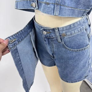 Detail of blue denim skirt-shorts with yellow topstitching and silver metal buttons