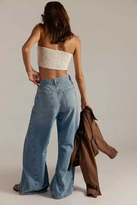Detailed back view of high-waisted wide-leg jeans with vintage light blue denim texture