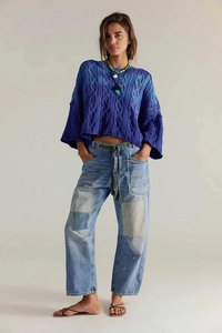 Détails du pull en maille torsadée bleu dégradé et du jean patchwork avec bords effilochés