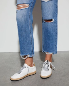 Detail of white leather low-top sneakers with leopard star patch and silver glitter laces