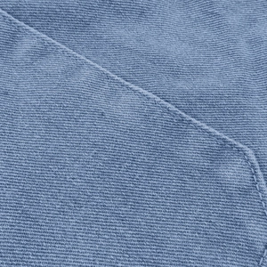 Close-up of blue denim fabric with twill weave and high-quality stitching detail