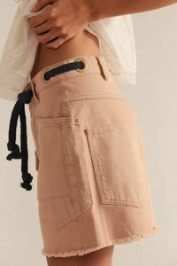 Detail of cargo denim shorts featuring large side pockets and braided drawstring waist