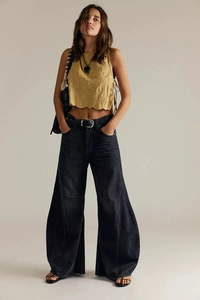 Close-up of yellow embroidered vest paired with black high-waisted wide-leg jeans