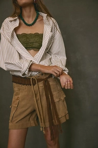 Détail du short cargo kaki avec ceinture tressée marron et chemise à rayures larges