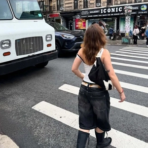 Street style άποψη από ξεπλυμένη γκρι τζιν βερμούδα με ψηλή μέση σε διάβαση πεζών