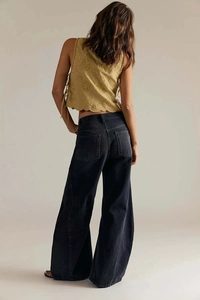 Detail of mustard vest with floral embroidery and high-waisted wide-leg jeans back view