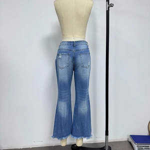 Detail van blauwe flared jeans met hoge taille, gescheurde zak en gerafelde zomen