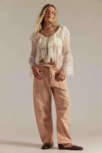Détail d'un pantalon cargo rose avec des taches de peinture blanche et cordon de serrage