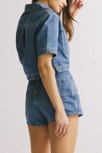 Detalle del conjunto vaquero de dos piezas con camisa azul de manga corta y pantalón corto