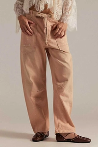 Vue détaillée du pantalon cargo orange-rose avec des taches de peinture et cordon de serrage