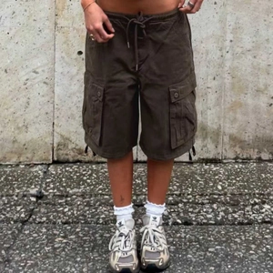 Detail of dark brown cargo shorts showing elastic drawstring waist and large flap pockets