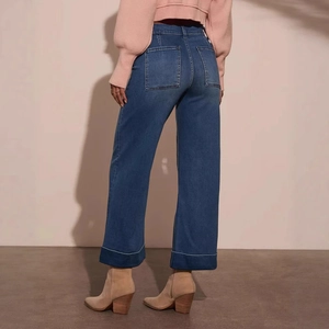 Dettaglio dei jeans a gamba larga a vita alta con tasche posteriori e orlo risvoltato