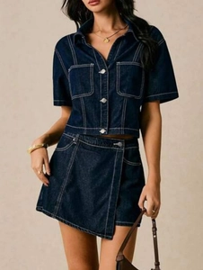 Detail of dark blue denim set featuring contrast white stitching and metal buttons