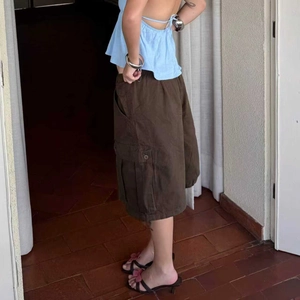 Detail of brown cargo shorts featuring classic side pockets and relaxed summer fit