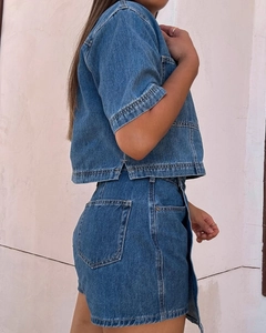 Detalle del conjunto vaquero azul oscuro con costuras amarillas y textura de tela