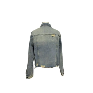 Detail view of back of a light blue cropped denim jacket with distressed ripped accents