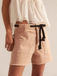 Women's light pink denim shorts featuring black drawstring rope and metal eyelets