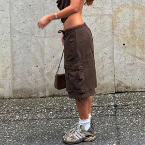 Detail of cargo skirt side pocket and drawstring waist in dark coffee color
