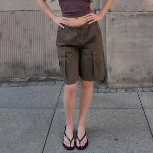 Detail of dark brown cargo shorts with elastic drawstring waist and side flap pockets