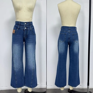 Detail view showing high-waist wide-leg blue denim jeans with double button closure