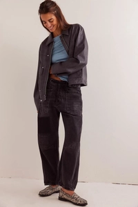 Détail d'une veste vintage en similicuir gris et d'un pantalon large avec empiècement