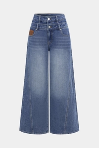 Detail of high-waisted blue jeans featuring a double waistband and two silver buttons