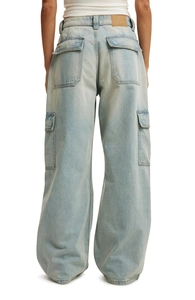 Detail view of the large flap back pockets on these light blue washed cargo denim pants