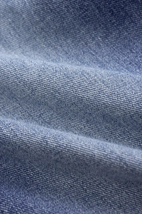 Macro view of blue denim fabric with twill texture and vintage washed finish detail