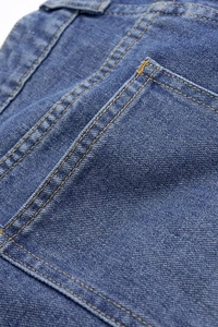 Detailed close-up showing high-quality reinforced stitching on blue denim back pocket