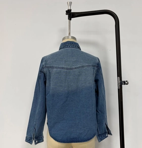 Back view of a loose denim shirt in washed blue with detailed shoulder stitching