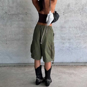 Rear view of loose cargo shorts in army green with elastic drawstring and side pockets